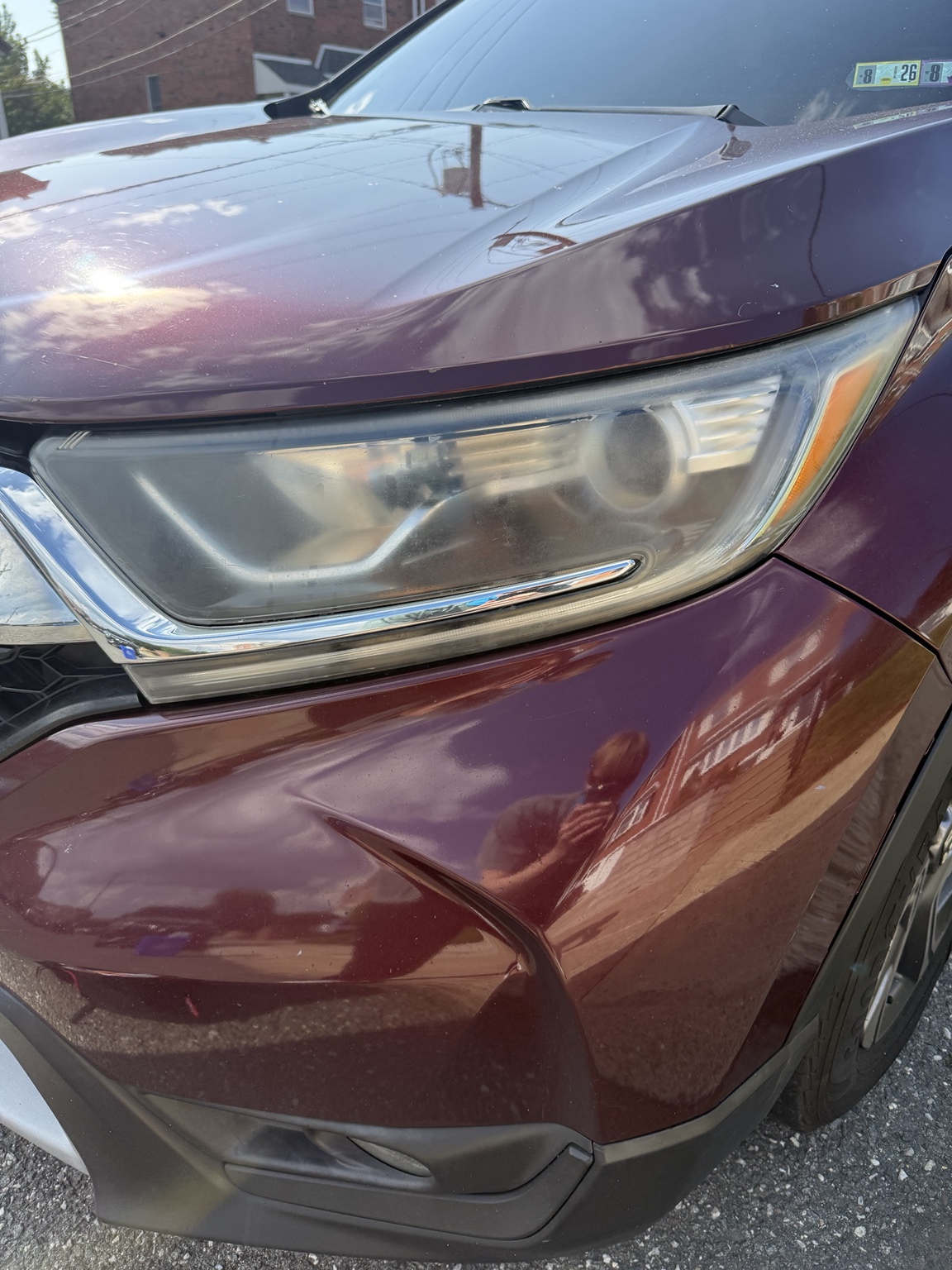 Cloudy headlight on a burgundy SUV before restoration