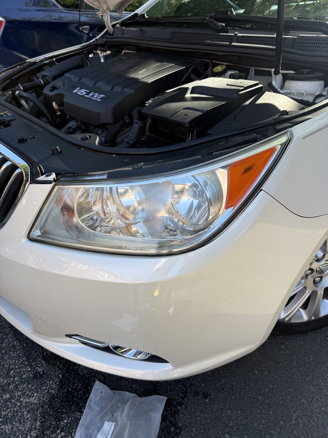 Clear headlight on the same white sedan after restoration
