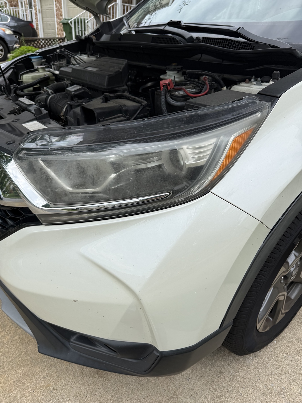 Oxidized headlight on a white SUV before restoration